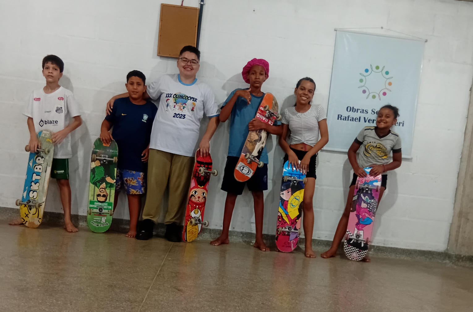 Crianças com skates em frente ao logo da OSRV